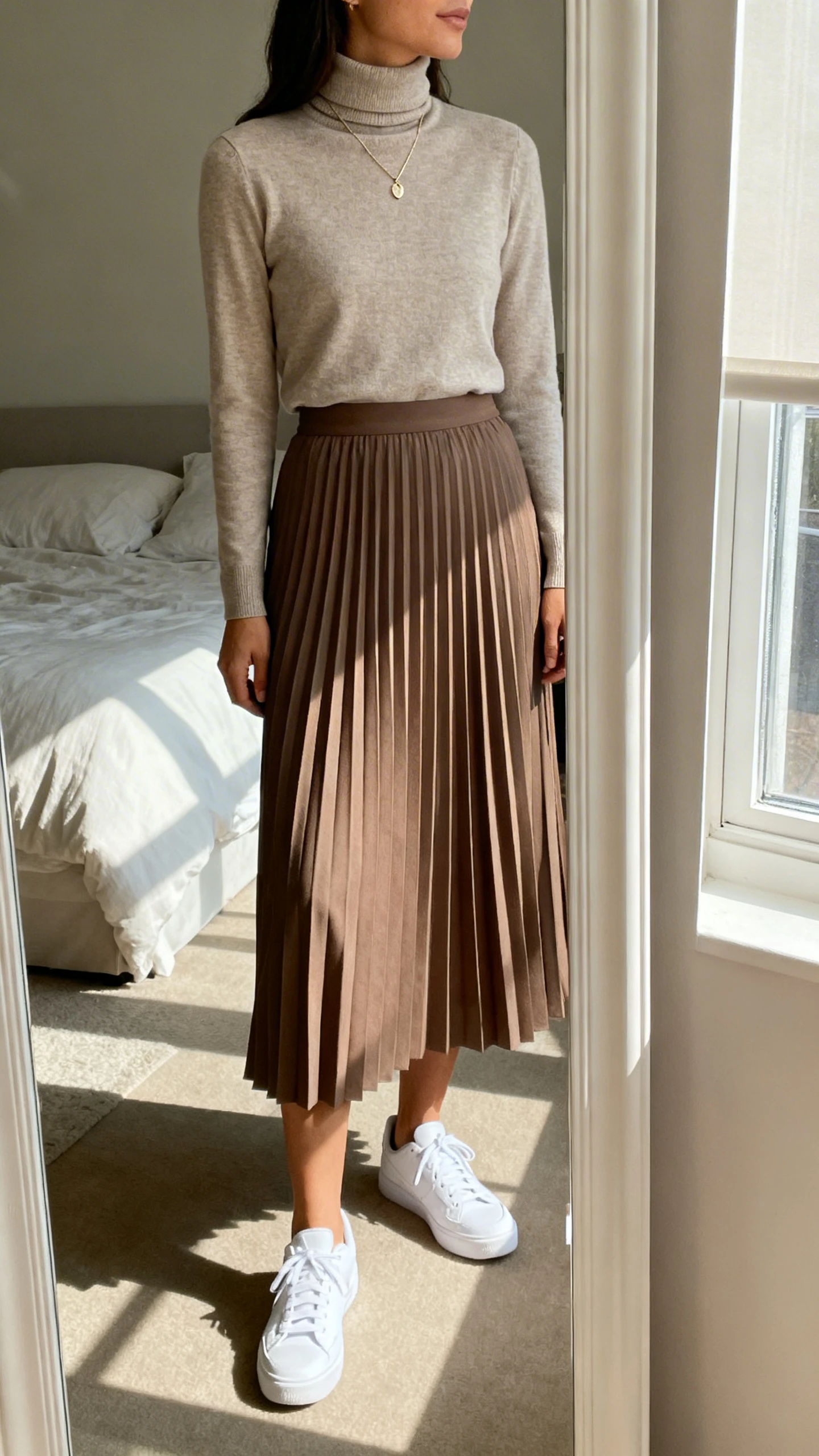 iPhone mirror selfie of a woman wearing a turtleneck tucked into a pleated midi skirt with clean white sneakers and a delicate pendant, face not visible, side angle, bedroom full-length mirror, natural window light, iPhone photo quality